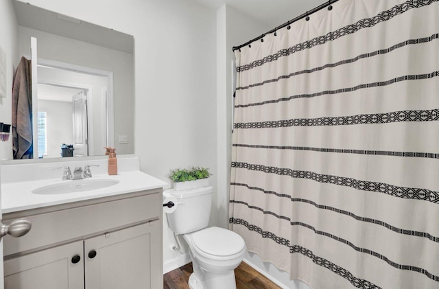 bathroom with vanity, a shower with curtain, toilet, and wood finished floors