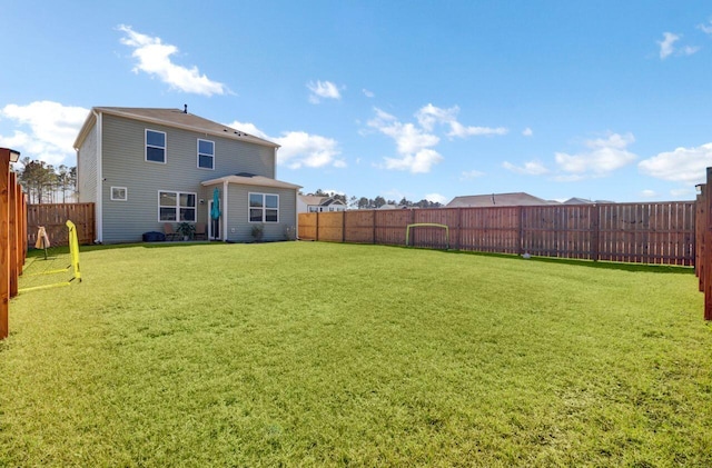 back of house with a lawn and a fenced backyard