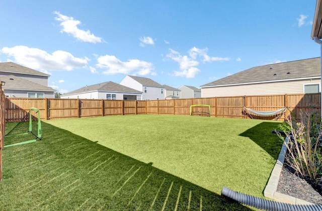 view of yard featuring a fenced backyard and a residential view