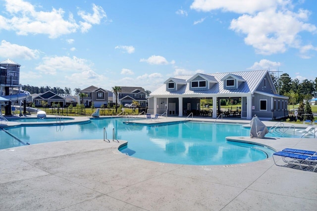 pool featuring a patio area, a water slide, and fence