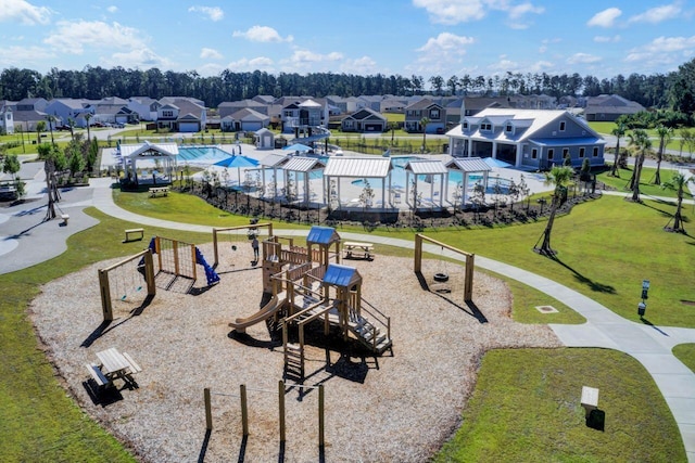 view of property's community with playground community, a residential view, and a yard