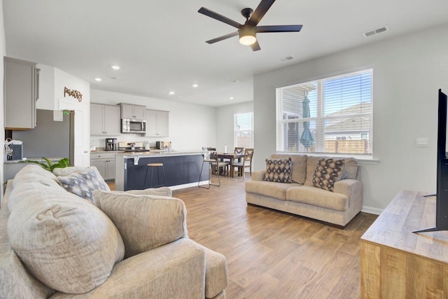 living area featuring recessed lighting, a ceiling fan, and light wood-type flooring