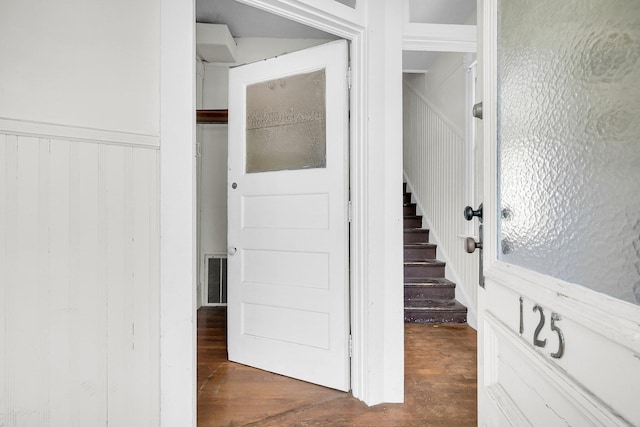 stairs with wood finished floors and visible vents