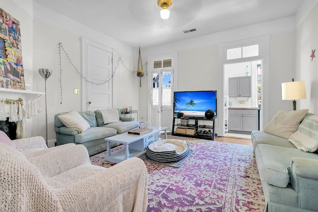 living area featuring visible vents and wood finished floors