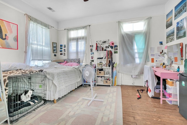 bedroom featuring visible vents and hardwood / wood-style flooring