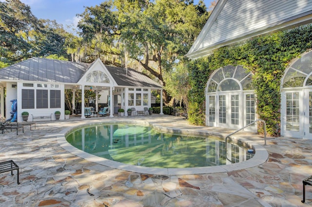 view of pool with french doors and a patio area