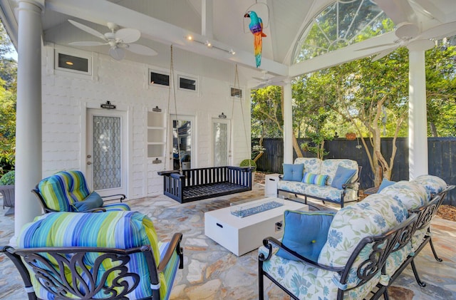 view of patio featuring ceiling fan and an outdoor living space with a fire pit