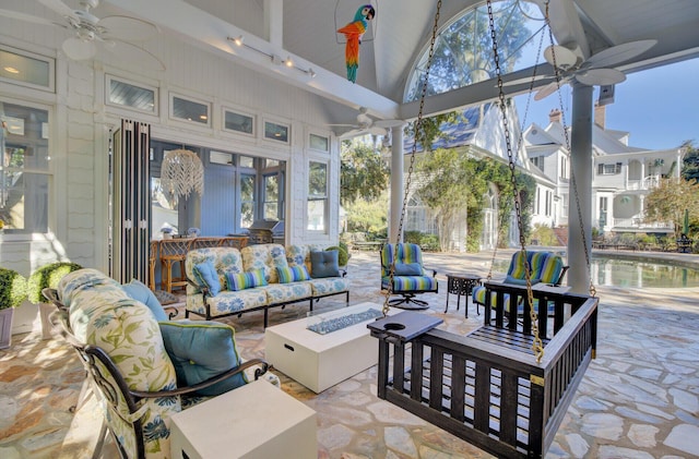 sunroom featuring ceiling fan and vaulted ceiling