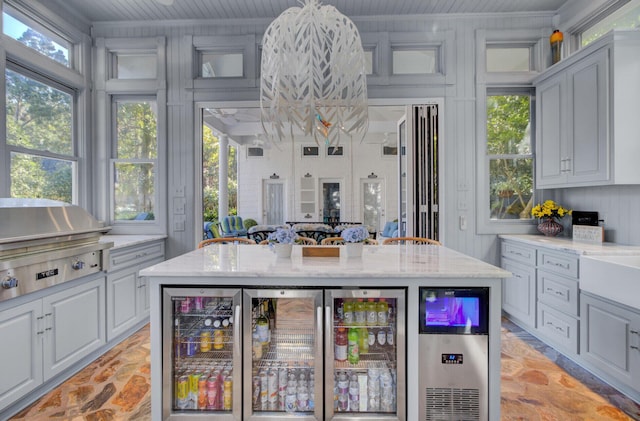 kitchen featuring light stone counters, a wealth of natural light, and wooden ceiling