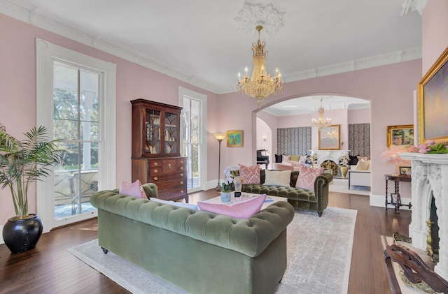 living room featuring dark hardwood / wood-style flooring, ornamental molding, and a notable chandelier