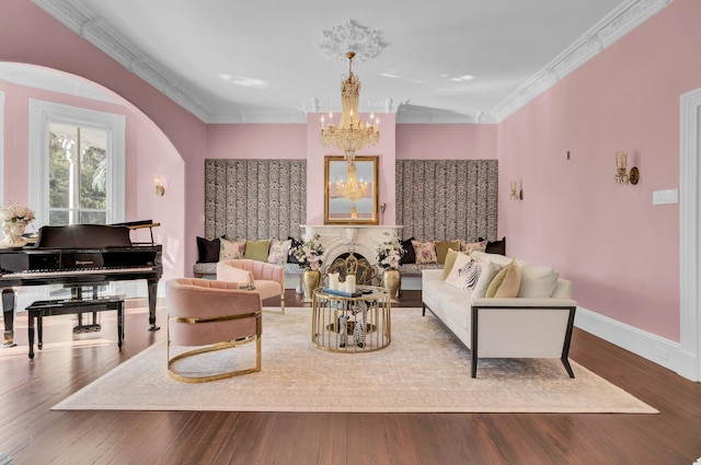 living room with hardwood / wood-style floors, an inviting chandelier, and crown molding