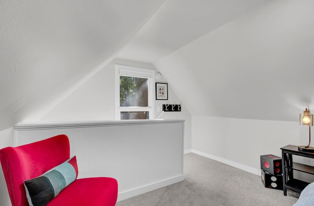 sitting room featuring light colored carpet and vaulted ceiling