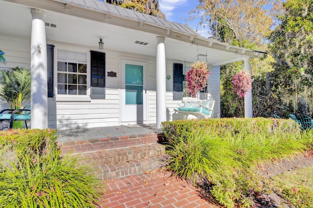 view of exterior entry with a porch