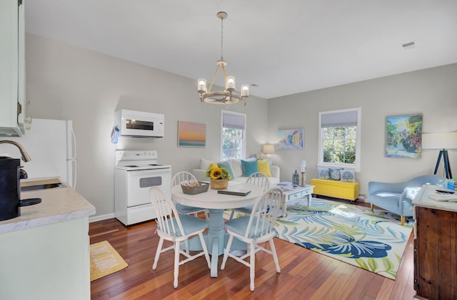 dining room featuring an inviting chandelier, dark wood-type flooring, and sink