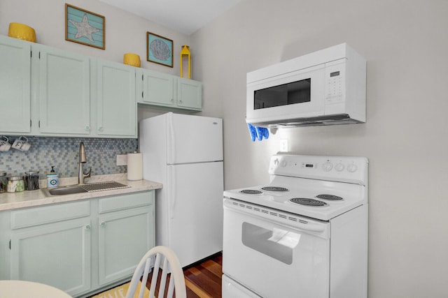 kitchen featuring dark hardwood / wood-style flooring, white appliances, tasteful backsplash, and sink