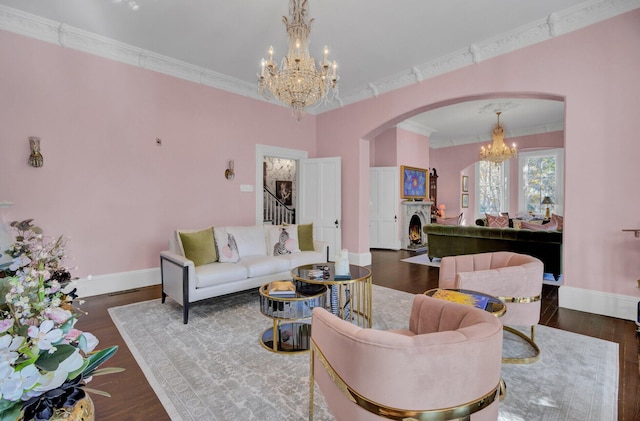 living room with ornamental molding, dark wood-type flooring, and a notable chandelier