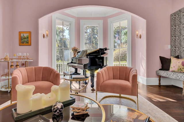 sitting room featuring a healthy amount of sunlight, dark wood-type flooring, and ornamental molding