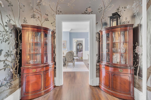 entryway with wood-type flooring and ornamental molding