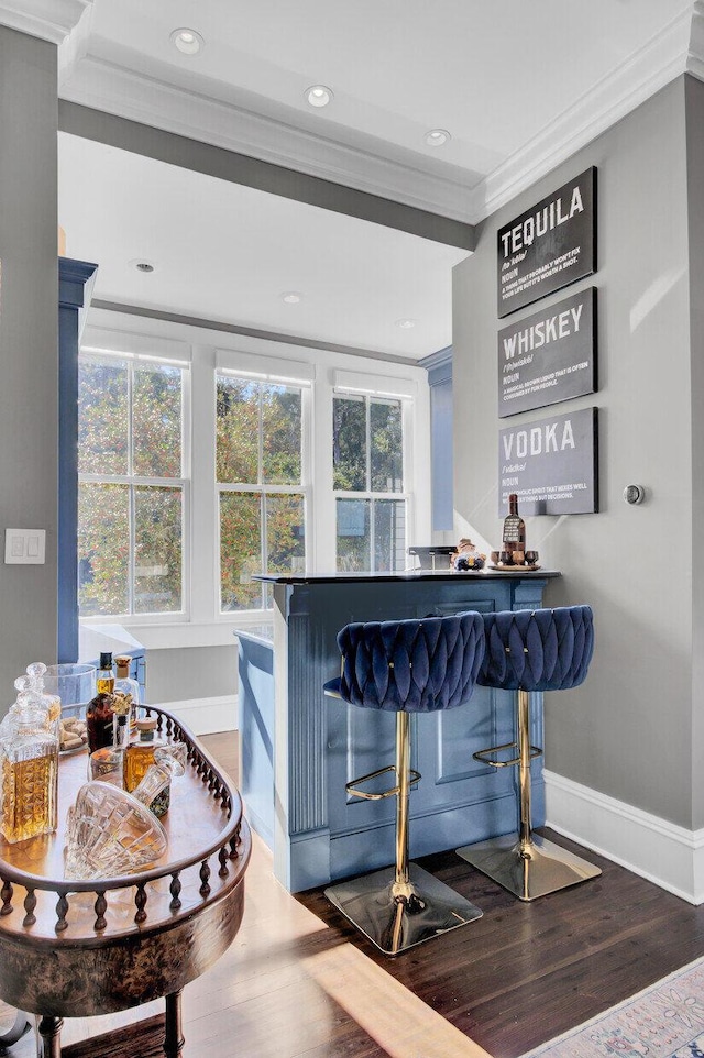 bar with hardwood / wood-style floors and crown molding