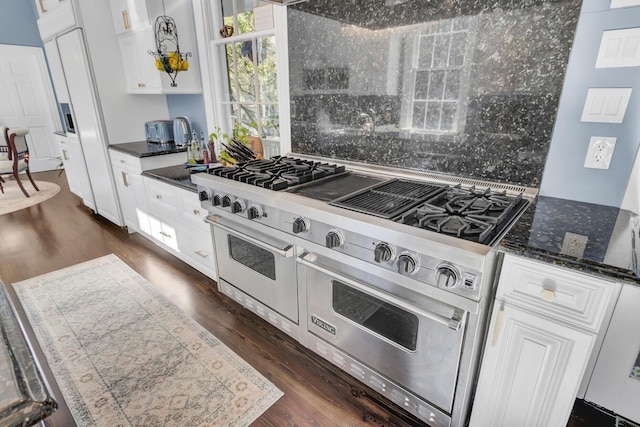 kitchen with white cabinets, range with two ovens, and dark wood-type flooring