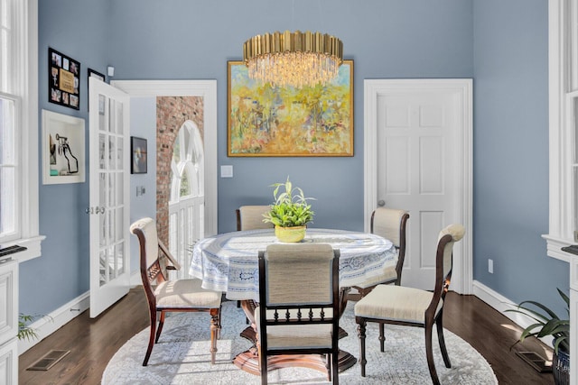 dining space with a chandelier, french doors, dark hardwood / wood-style flooring, and plenty of natural light