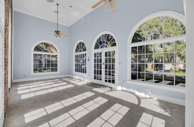 unfurnished sunroom featuring ceiling fan, french doors, and lofted ceiling