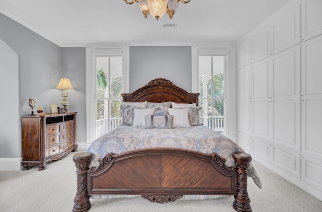 carpeted bedroom with crown molding, a closet, and a chandelier