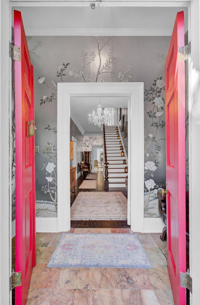 entryway featuring ornamental molding and an inviting chandelier