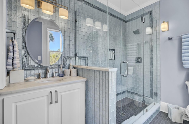 bathroom with vanity, a shower with shower door, and crown molding