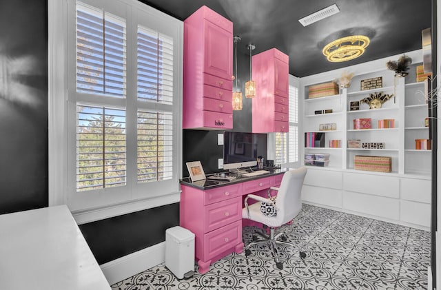 office with light tile patterned floors and built in desk