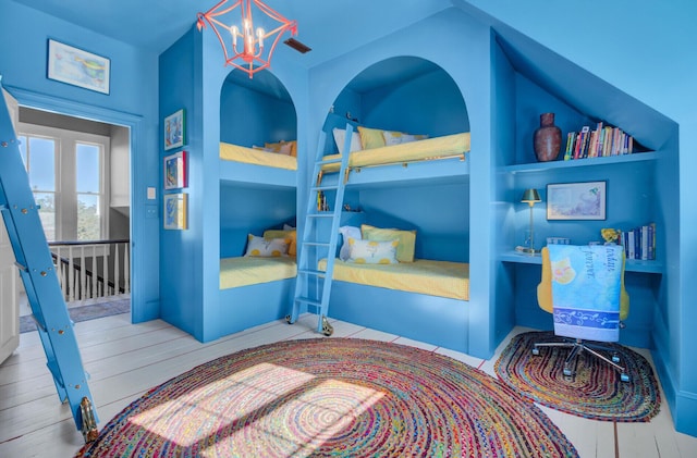 bedroom featuring light wood-type flooring and an inviting chandelier