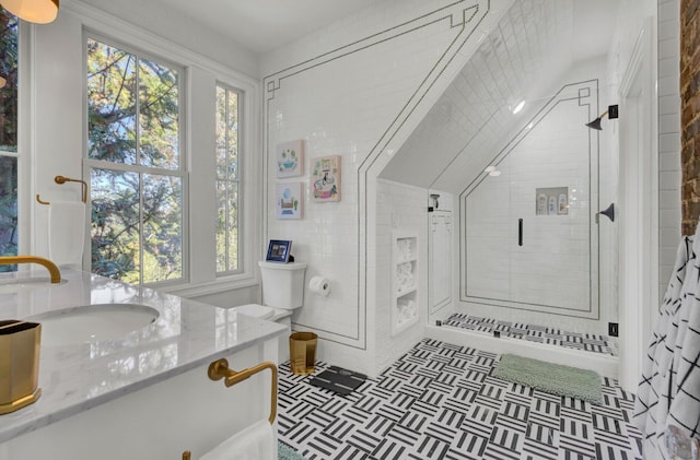 bathroom featuring tile patterned floors, vanity, tiled shower, and tile walls