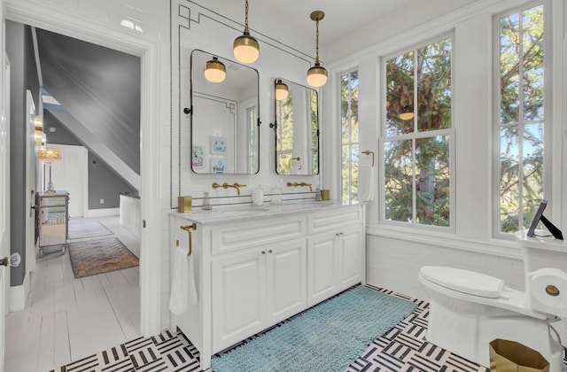 bathroom with plenty of natural light, vanity, and toilet