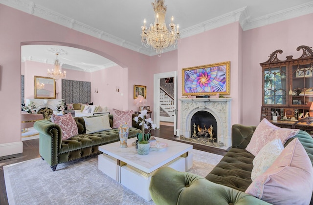 living room featuring a high end fireplace, hardwood / wood-style flooring, and ornamental molding