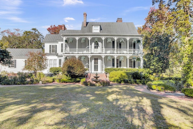 view of front of property with a front yard, french doors, and a balcony