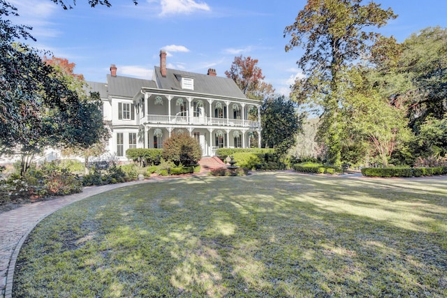 view of front of property featuring a porch, a balcony, and a front lawn