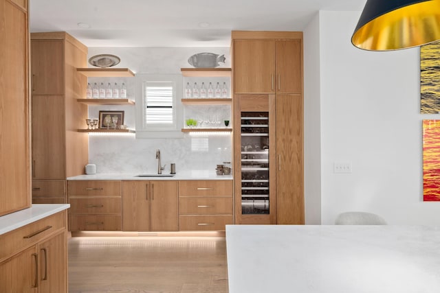 kitchen featuring wood finished floors, a sink, light countertops, open shelves, and tasteful backsplash