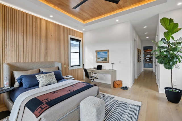 bedroom with light wood-type flooring, wood ceiling, a raised ceiling, and recessed lighting