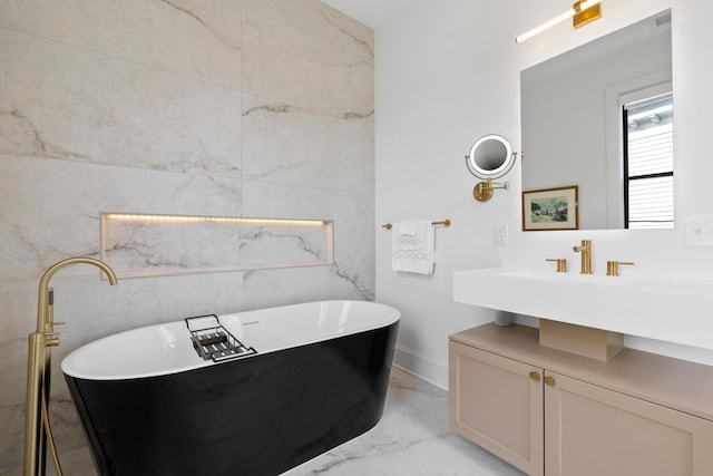 bathroom featuring marble finish floor and a soaking tub