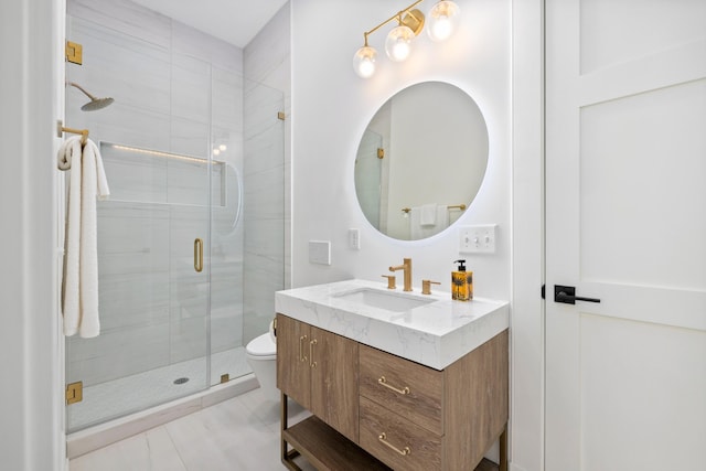 bathroom with toilet, a shower stall, and vanity