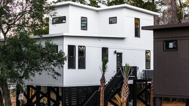 view of front of home featuring stairway and central AC unit