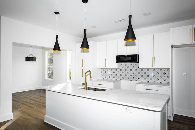 kitchen featuring dark wood finished floors, a sink, white cabinets, black microwave, and backsplash