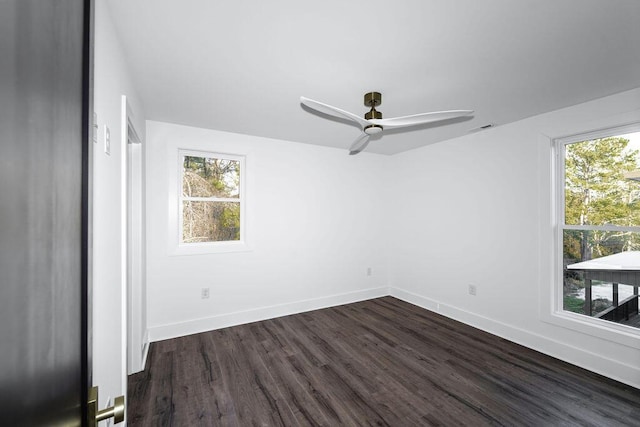 spare room featuring visible vents, baseboards, ceiling fan, and dark wood-style flooring