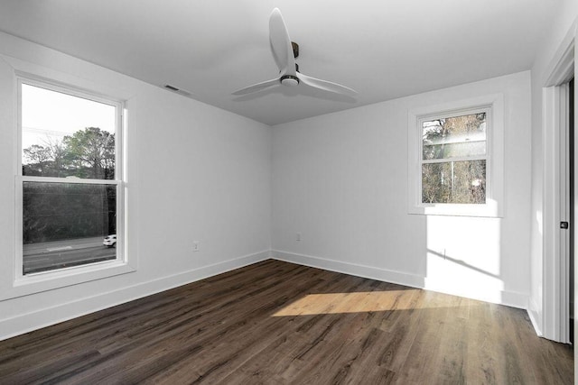 unfurnished room featuring dark wood-type flooring, visible vents, baseboards, and ceiling fan