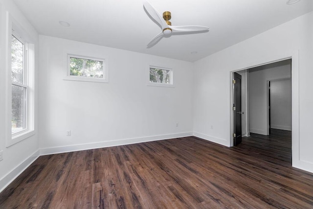 unfurnished room with baseboards, plenty of natural light, ceiling fan, and dark wood-style flooring