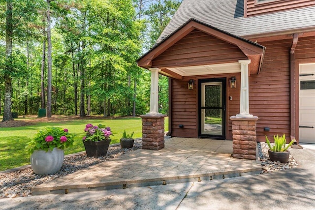 6840 Early Jersey Rd, Meggett, SC 29449 - view of exterior entry with a yard, a shingled roof, and a garage