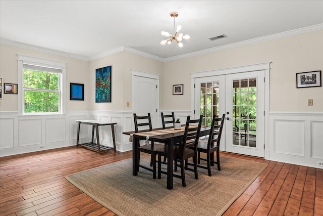6840 Early Jersey Rd, Meggett, SC 29449 - dining room featuring french doors, plenty of natural light, a chandelier, wood-type flooring, and crown molding