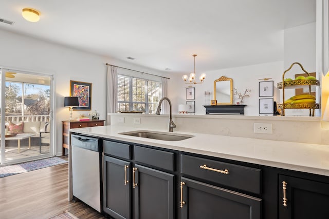 kitchen featuring pendant lighting, sink, dishwasher, a notable chandelier, and dark hardwood / wood-style flooring