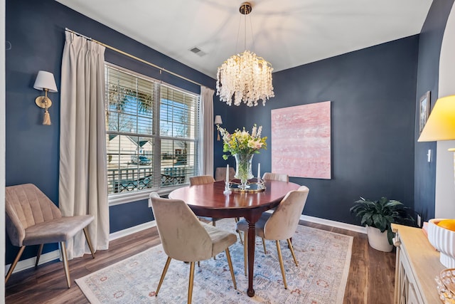 dining room with an inviting chandelier and dark hardwood / wood-style flooring