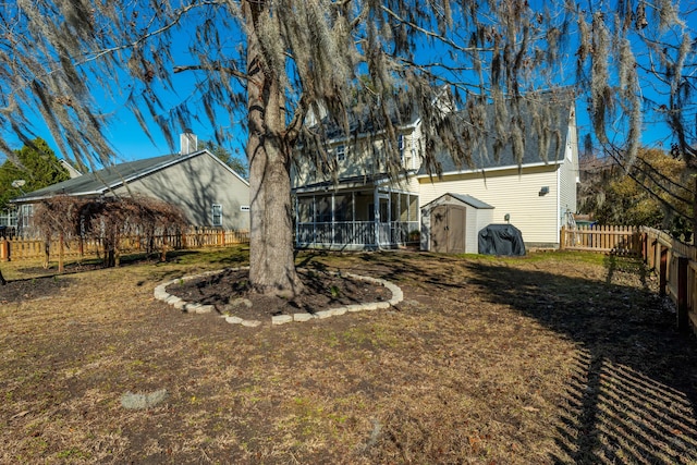 view of yard with a sunroom and a storage unit